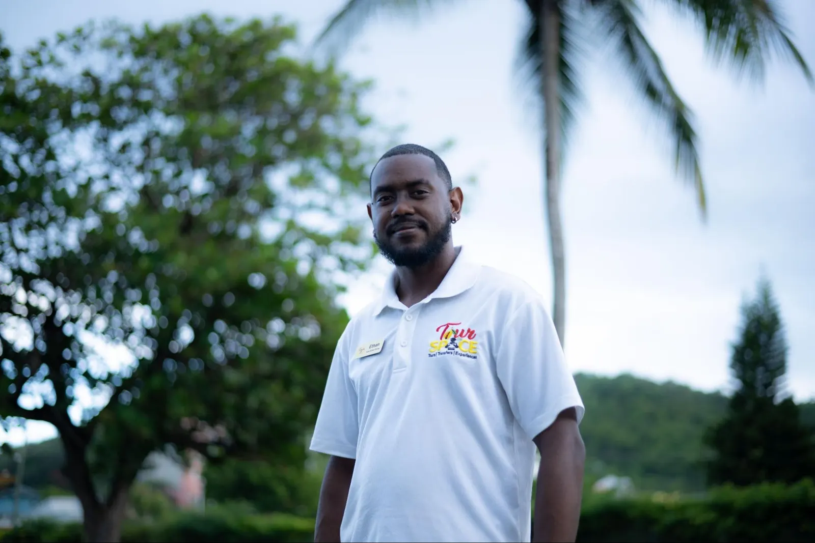 Ethan, Tour De Spice island guide, under palm trees in Grenada